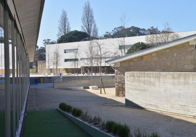 Pátio central com pedra e volumes brancos